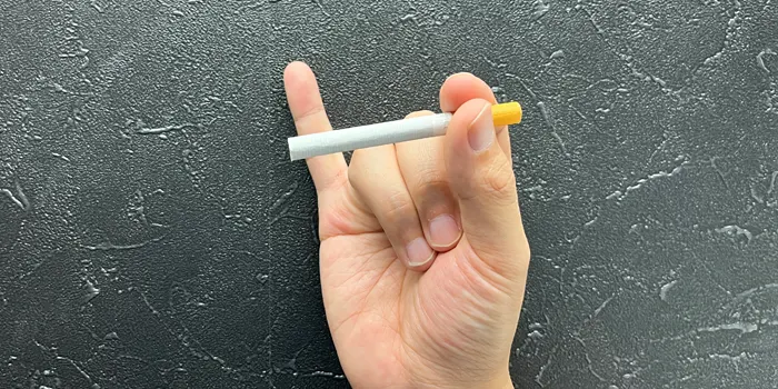 小指を立ててタバコを持つ