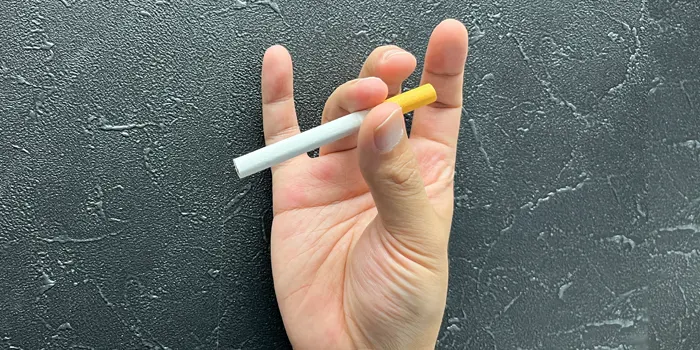 親指と薬指でタバコを持つ