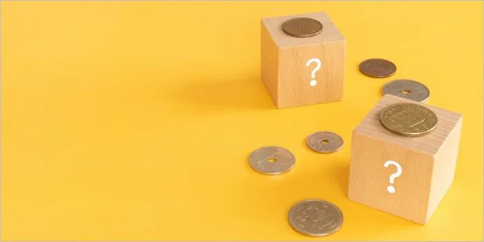 疑問符が書かれたブロックとコイン